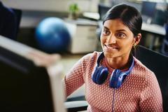 Female person with headphones, working on her computer